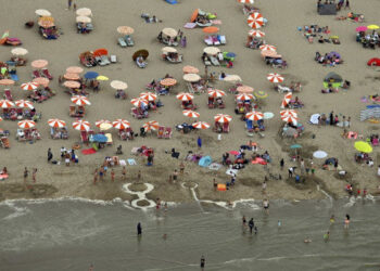 This aerial view taken on August 8, 2020, shows beachgoers sunbathing and playing in the sea on the beach of Knokke on the Belgian coast as heatwave sweeps across Europe. (Photo by ERIC LALMAND / BELGA / AFP) / Belgium OUT