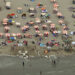 This aerial view taken on August 8, 2020, shows beachgoers sunbathing and playing in the sea on the beach of Knokke on the Belgian coast as heatwave sweeps across Europe. (Photo by ERIC LALMAND / BELGA / AFP) / Belgium OUT